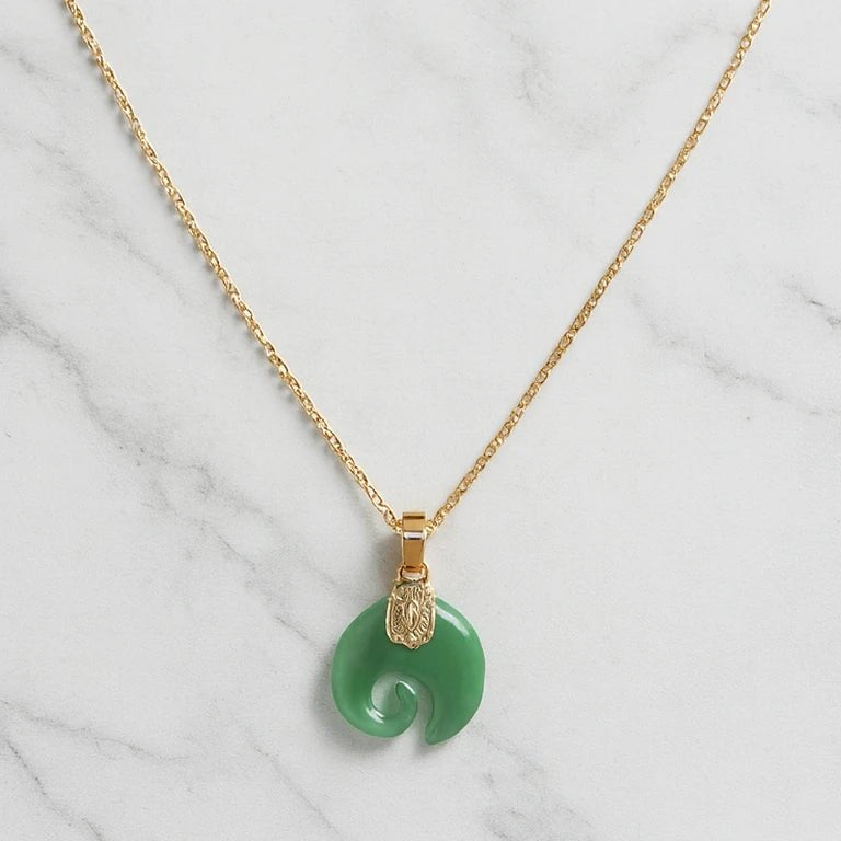 Collier Koru en jade vert avec chaîne dorée sur fond marbre — Klastora