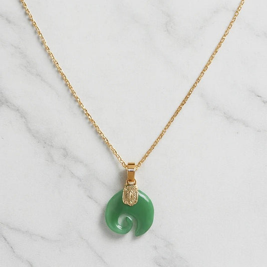 Collier Koru en jade vert avec chaîne dorée sur fond marbre — Klastora